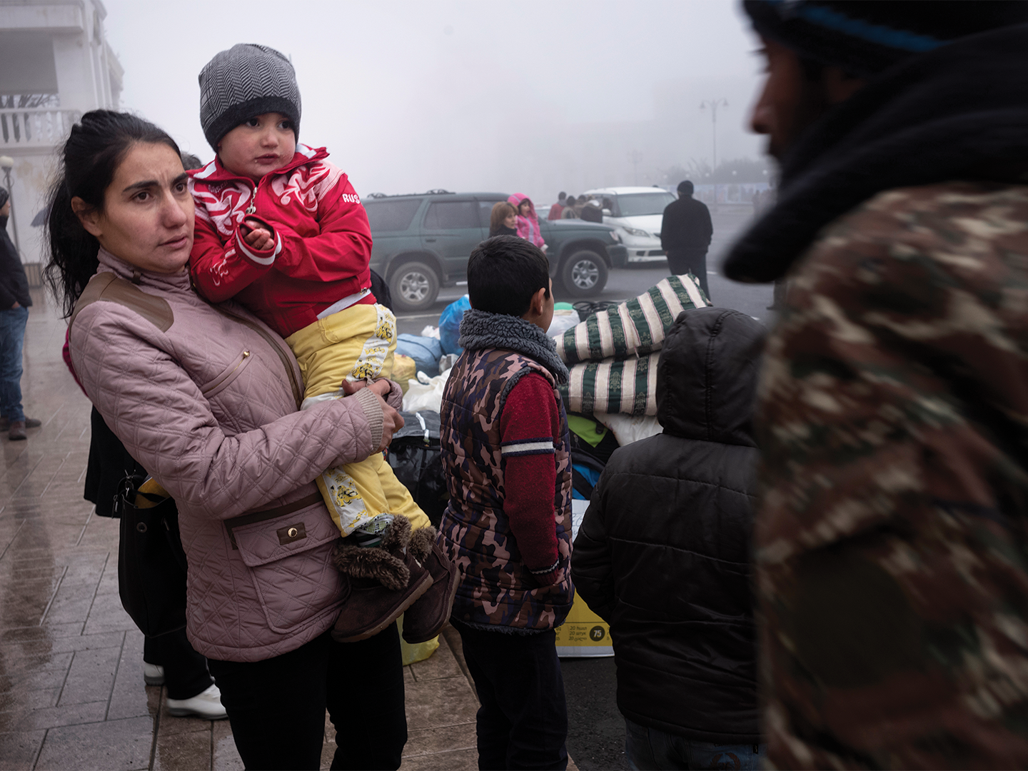 Narine Boghossyan holds her son, three and a half year old Armen Haroutunyan as they and her five other children wait in the freezing cold for a ride back to their home.