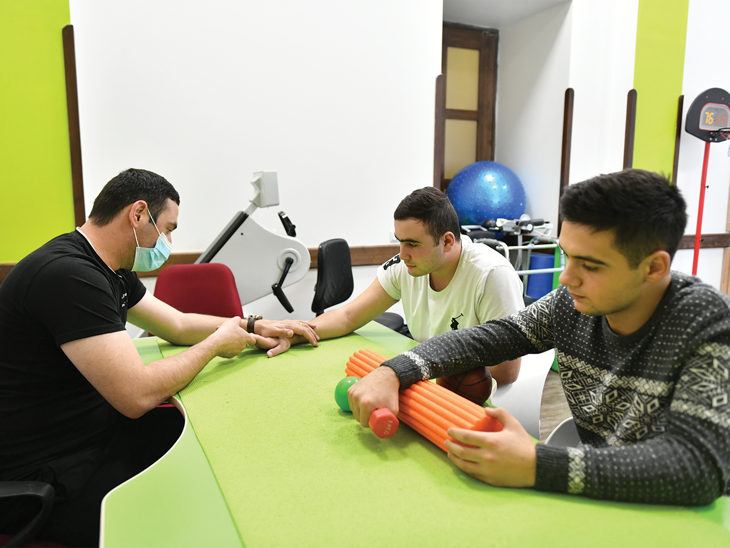 Artyom Arevikyan (middle) works to regain mobility back in his wrist that was injured by missile shrapnel.