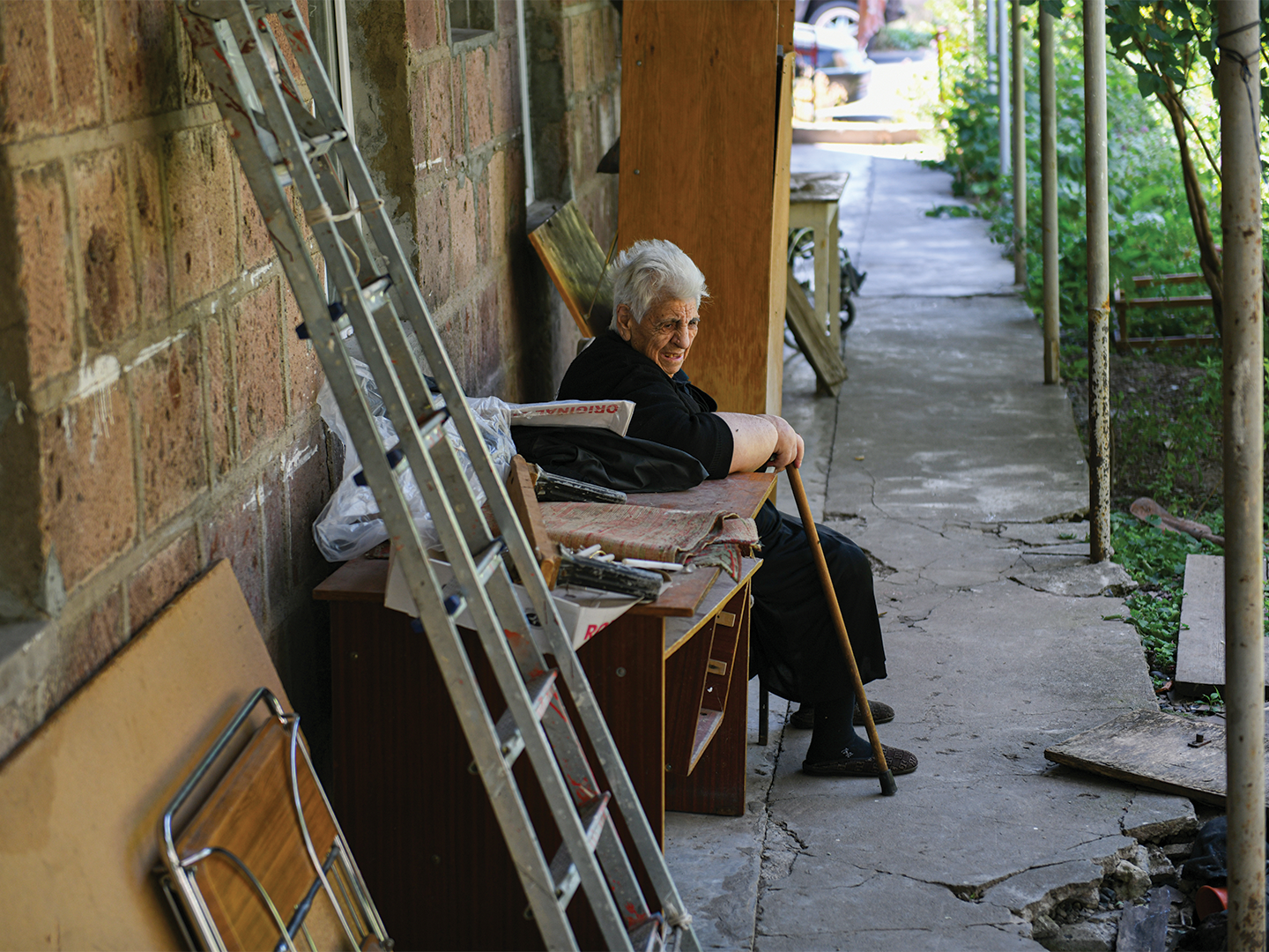 Older woman sitting outside a building.