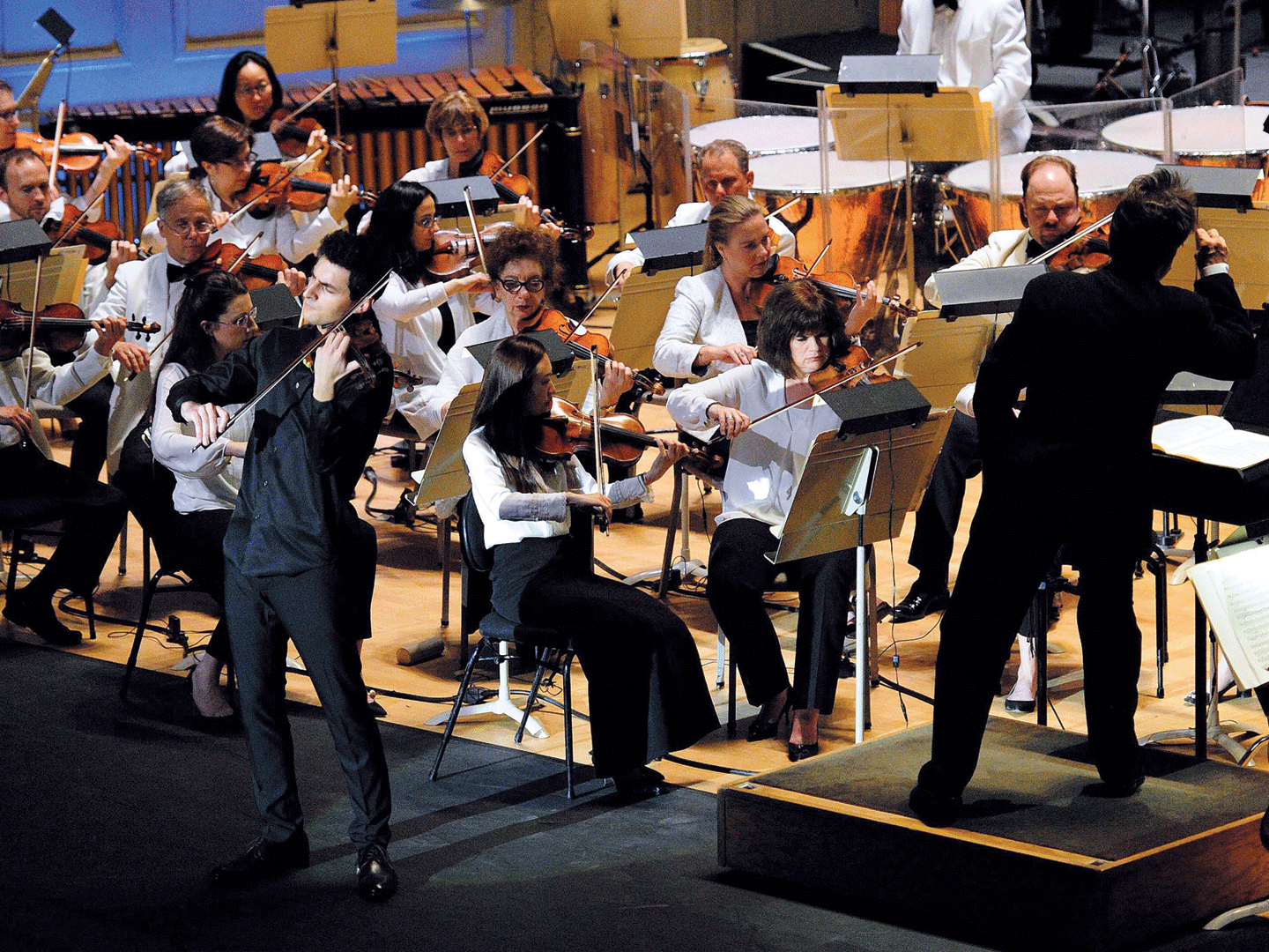 Violinist performs among an orchestra at Symphony Hall in Boston, MA in 2018.