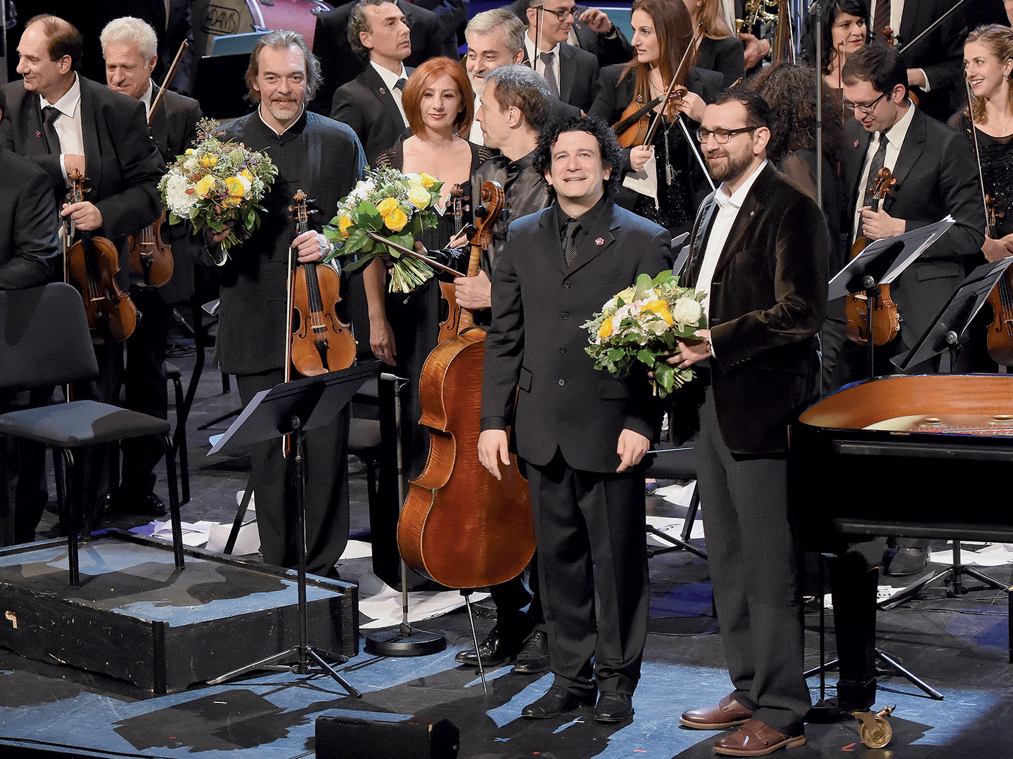 Male musician receives a bouquet of flowers at the conclusion of a concert