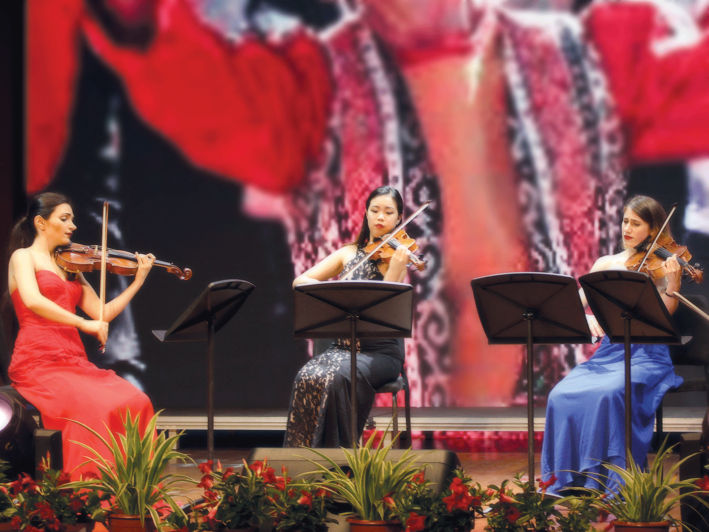 Astrid Poghosyan, female violinist performs along with two other violinists in a theater in Shangai