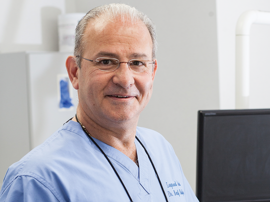 Doctor with glasses smiling in his clinic