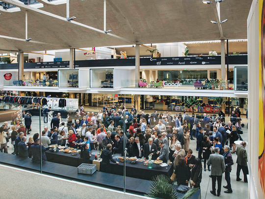 Attendees of the conference connect over lunch in the main hall of Station F.