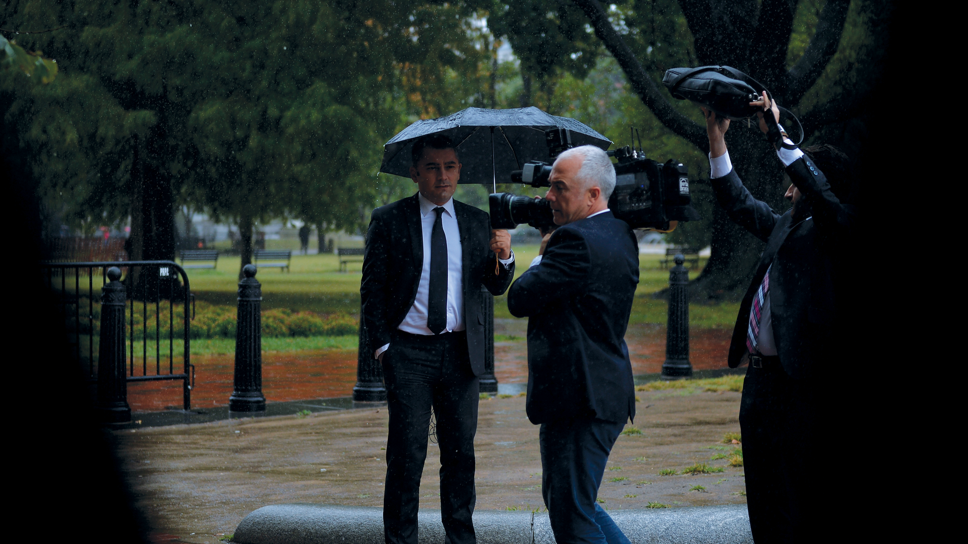 A Reporter in a black suit and an operator trying to cover news under water